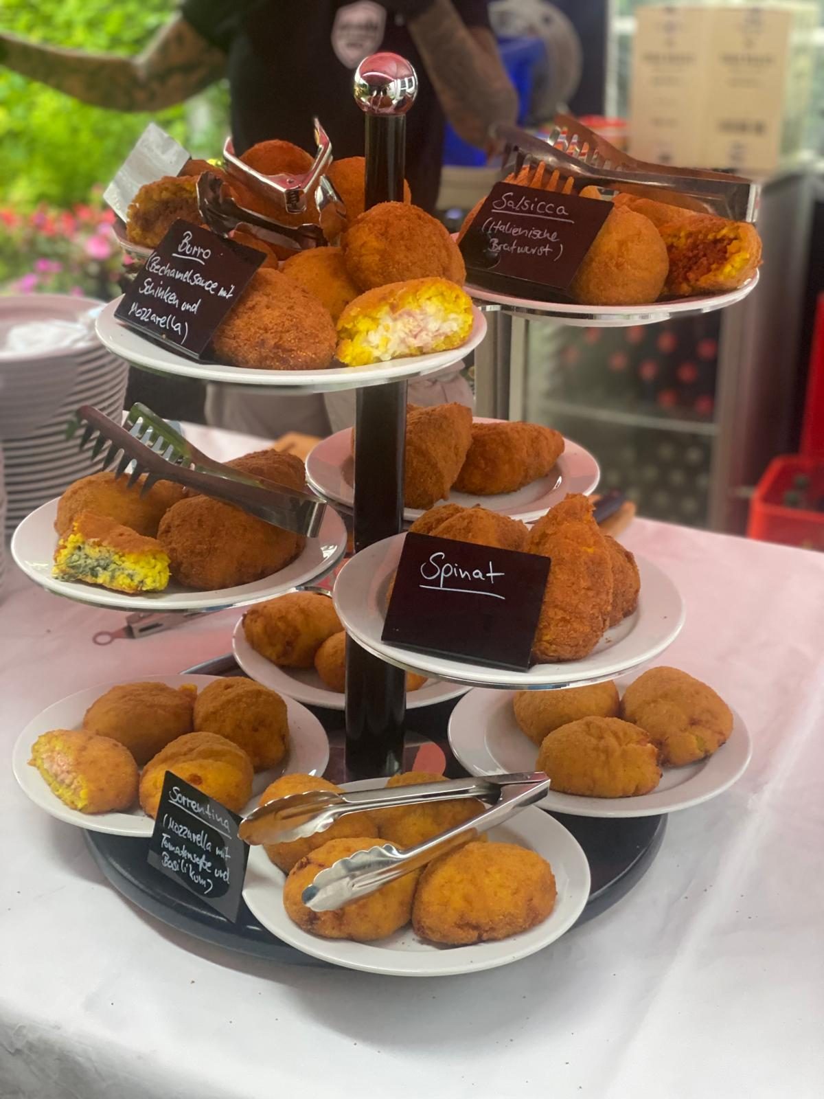 Etagere mit frisch frittierten Arancini in verschiedenen Füllungen auf einem BBQ-Event
