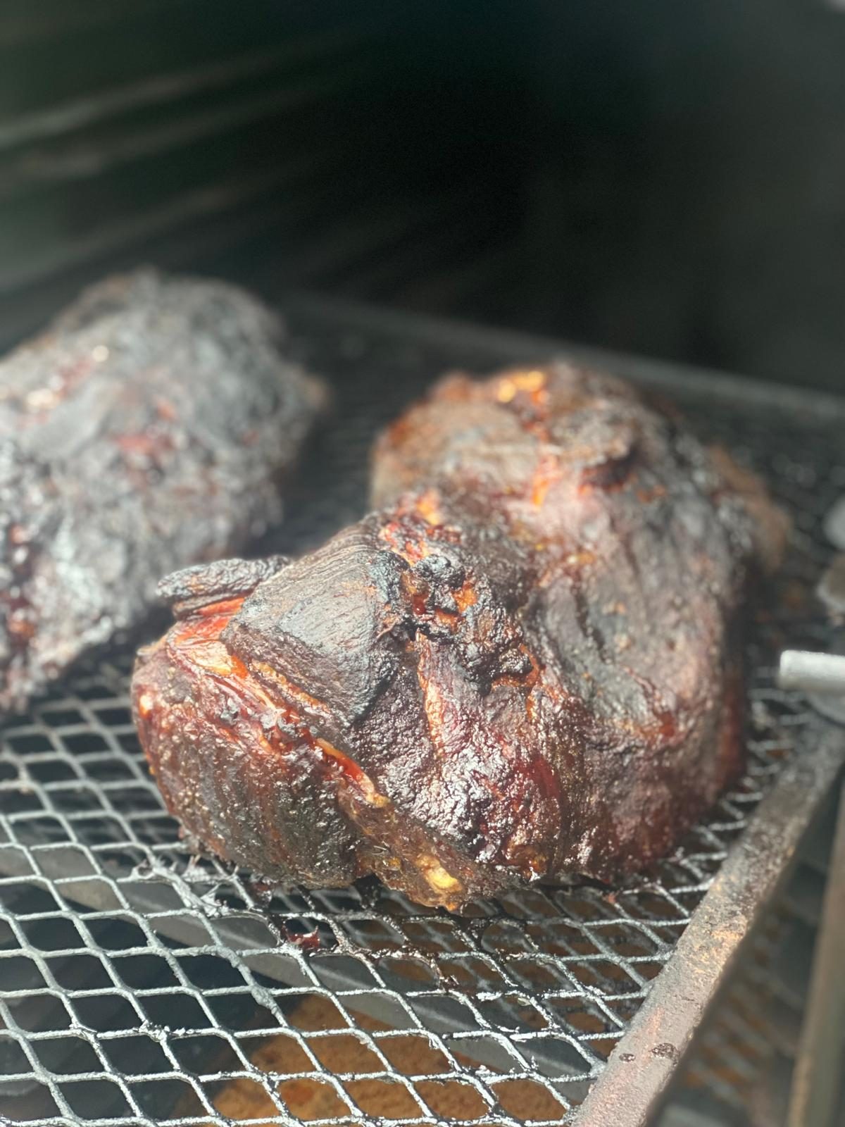 Zwei Stück Pulled Beef mit dunkler Kruste auf dem Rost unseres Smokers