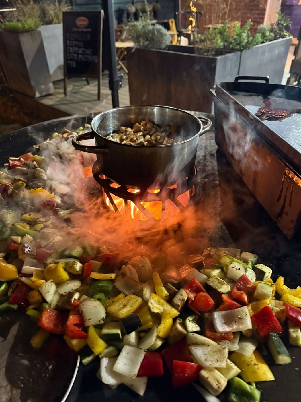 Gäste stehen mit gefüllten Tellern rund um die Grillstation